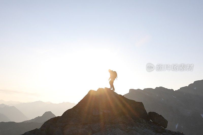 男徒步者登上山顶，日出