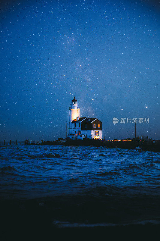 荷兰海岸风景如画的白色灯塔上方的星空