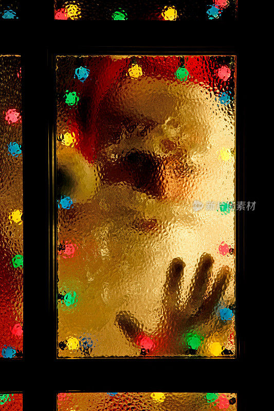 圣诞老人透过被灯光照亮的窗户向外看