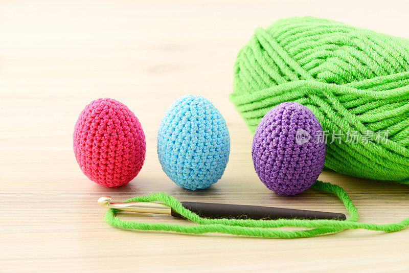 复活节彩蛋钩针与绿色羊毛球背景。