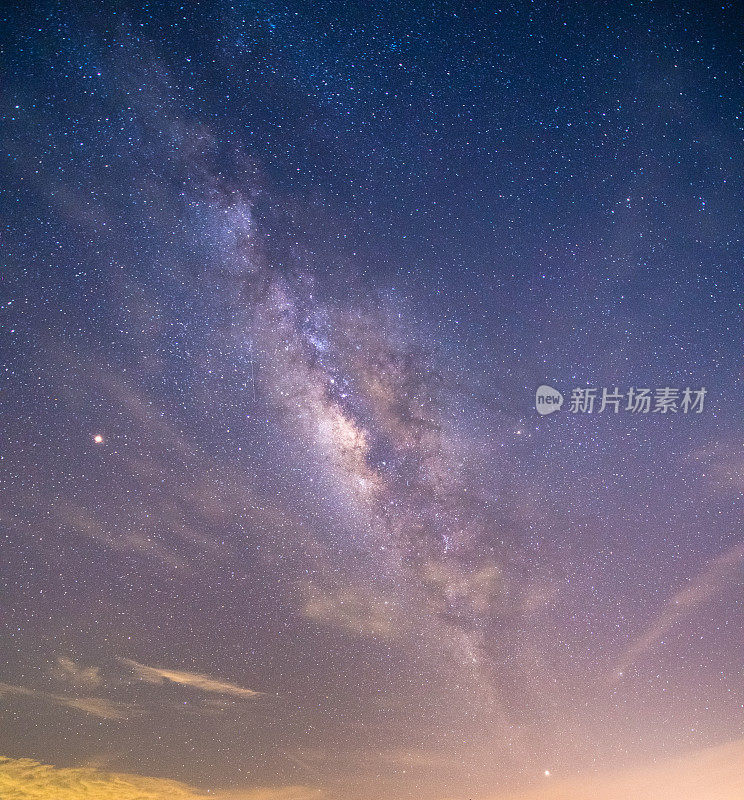 山上有银河和粉红的光。晚上多彩的景观。夏天的星空和山峦。美丽的宇宙。太空背景与星系。旅游的背景