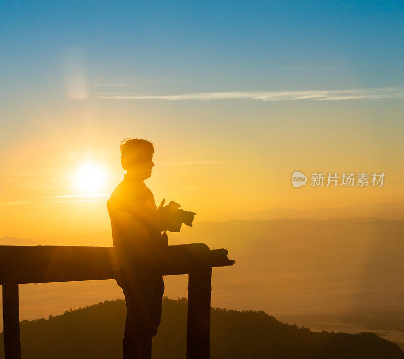 一名年轻人在泰国北部的吴康清迈自然景观日出景区用相机拍照