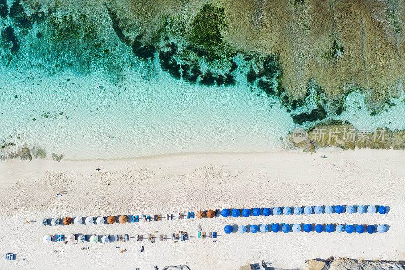 海滩伞和蓝色的海洋。从上面看海滩景色