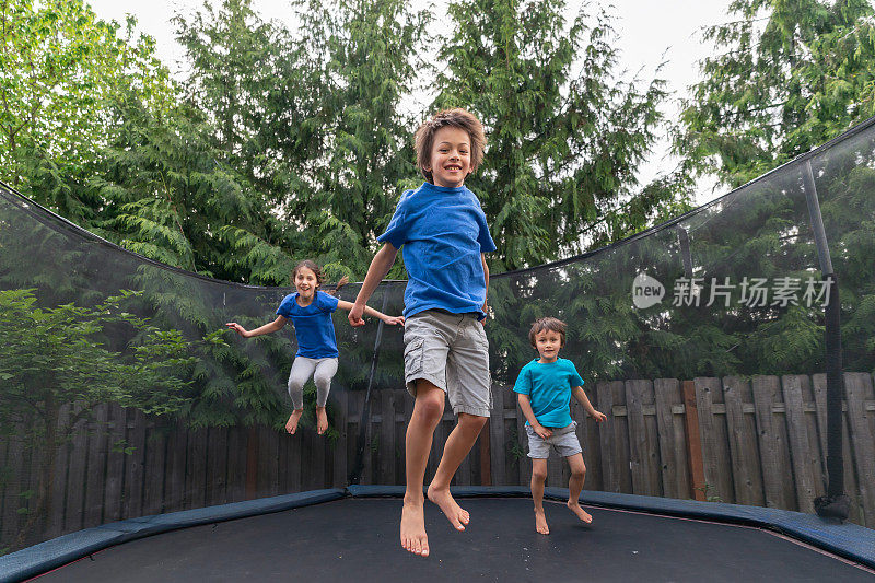 孩子们在没有父母在场的情况下在后院里跳蹦床