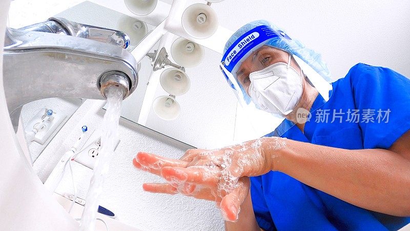 佩戴防护口罩和面罩洗手的女性医护人员