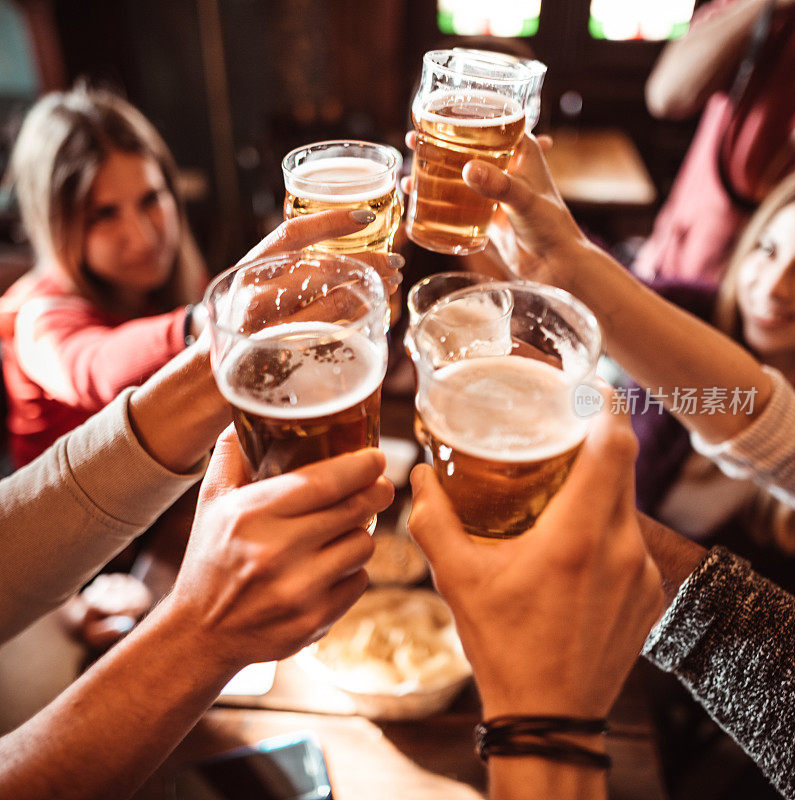 人们在酒吧里喝着啤酒聊天、敬酒