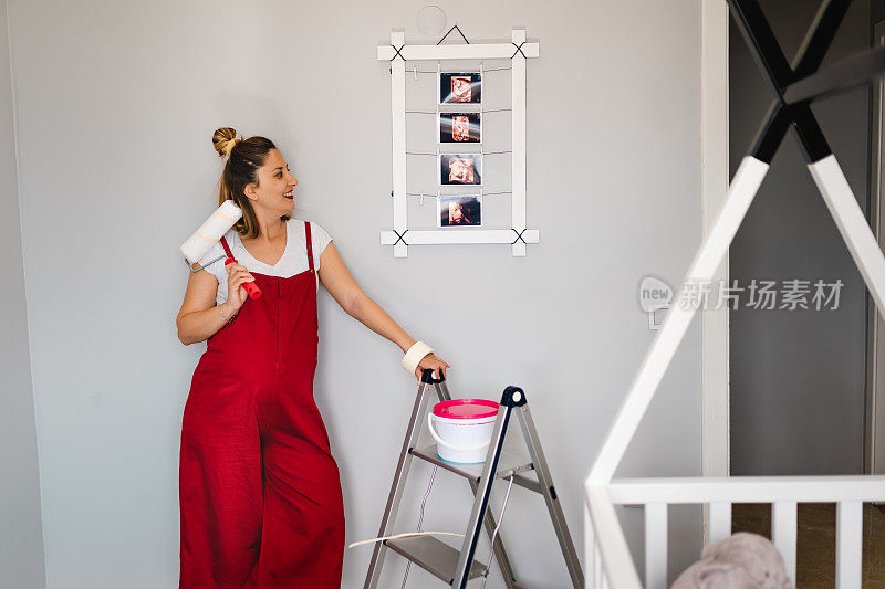 一位年轻的孕妇正在为她宝宝的新公寓墙壁选择合适的颜色。