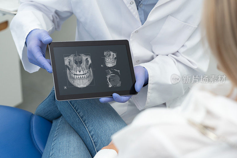 牙医在平板屏幕上显示牙齿x光
