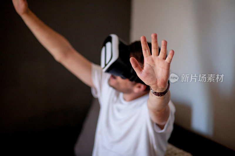 年轻人在家里使用虚拟现实模拟器耳机