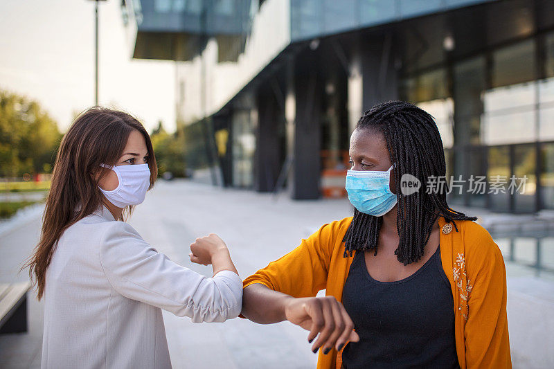 新冠肺炎大流行期间女同事相互问候、碰肘