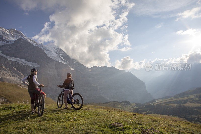 女性山地电动自行车在高山草甸中放松