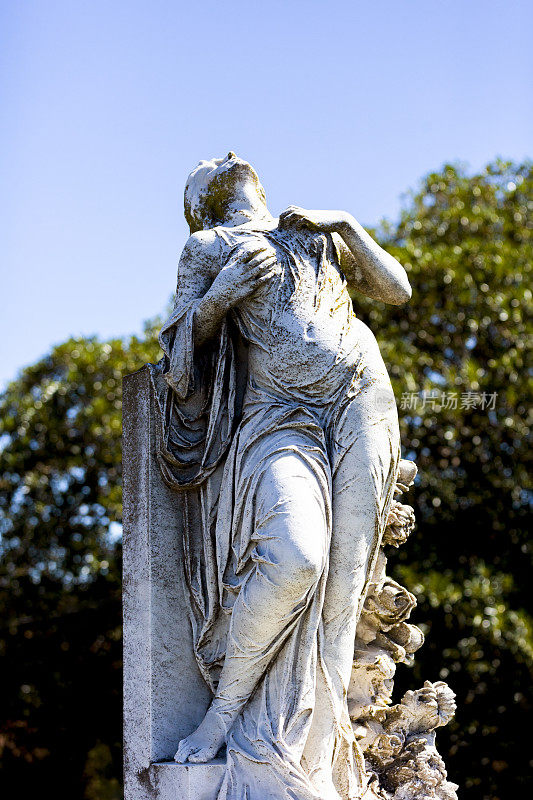 悲伤的年轻女子的老雕像双手放在胸前，背景与复制空间