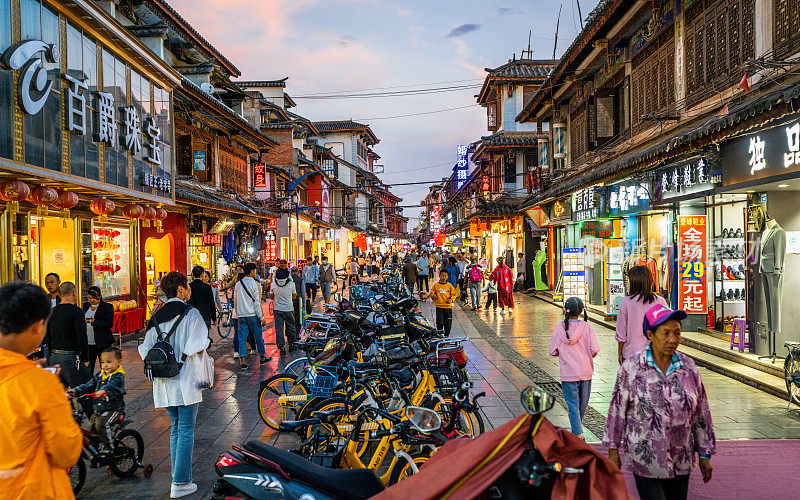 官渡老城购物街的街景，色彩斑斓的商店和人们在黄昏的云南昆明