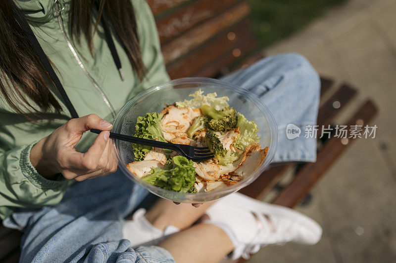 一个白人妇女在公园吃她的午餐的特写