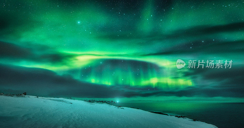 海洋上空的北极光。俄罗斯捷里别尔卡的北极光。星空，极地的光和云。夜景冬天有极光，海与模糊的水，雪山，星星。旅行