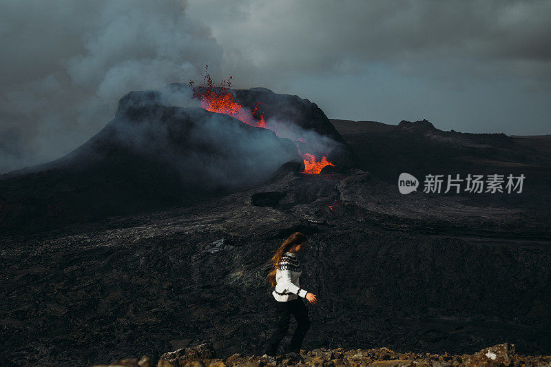 在冰岛Fagradalsfjall火山喷发时，一名妇女感到敬畏