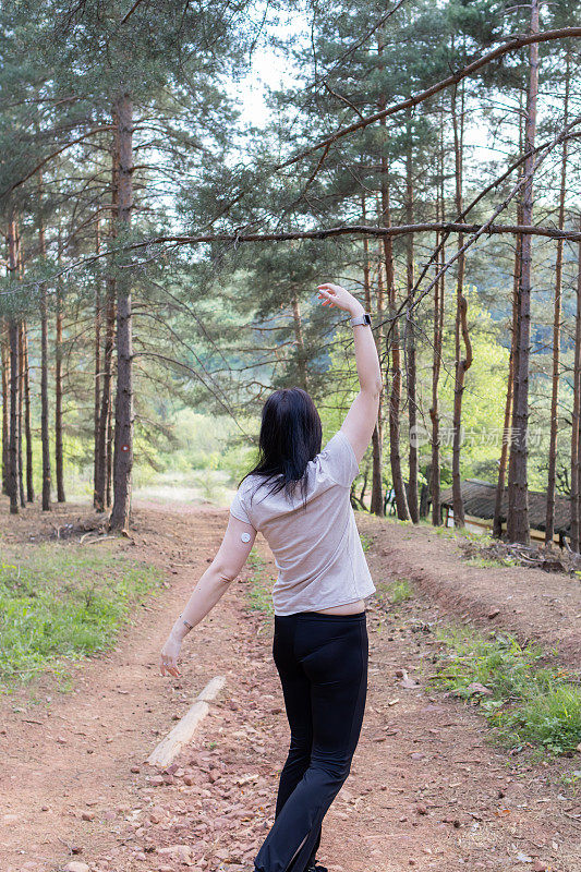 快乐的女跑步者正在森林里阳光明媚的小路上享受慢跑或越野跑。