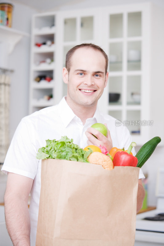 食品杂货和在厨房吃苹果的人