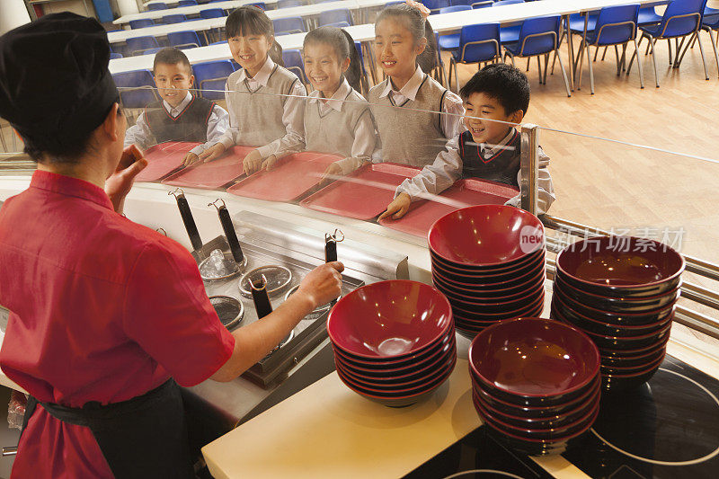 学校食堂工作人员为学生们提供面条