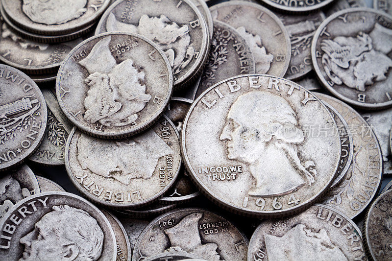 一堆旧的一角银币和25美分硬币