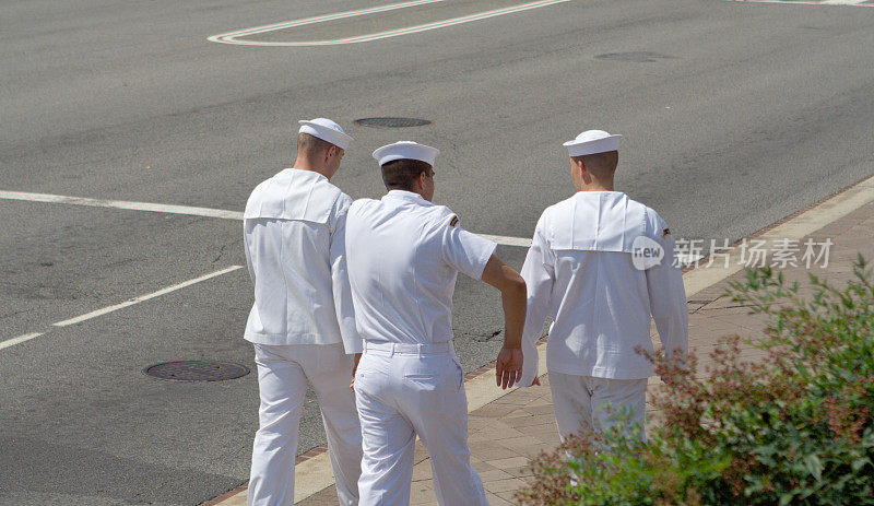 三个水手走在街上穿着白色衣服