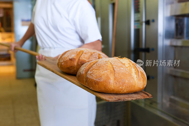 面包师烘烤面包，展示产品