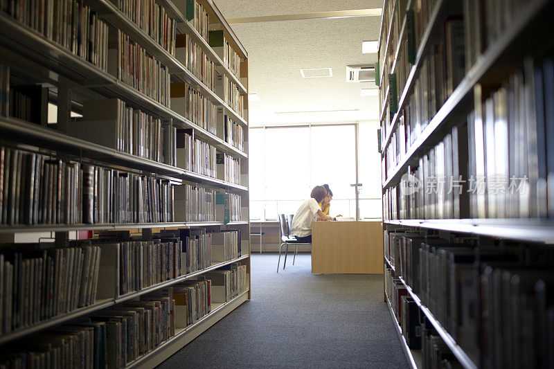 两个女学生在图书馆看书