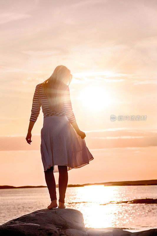 令人惊叹的照片的女人剪影在海滩上日落
