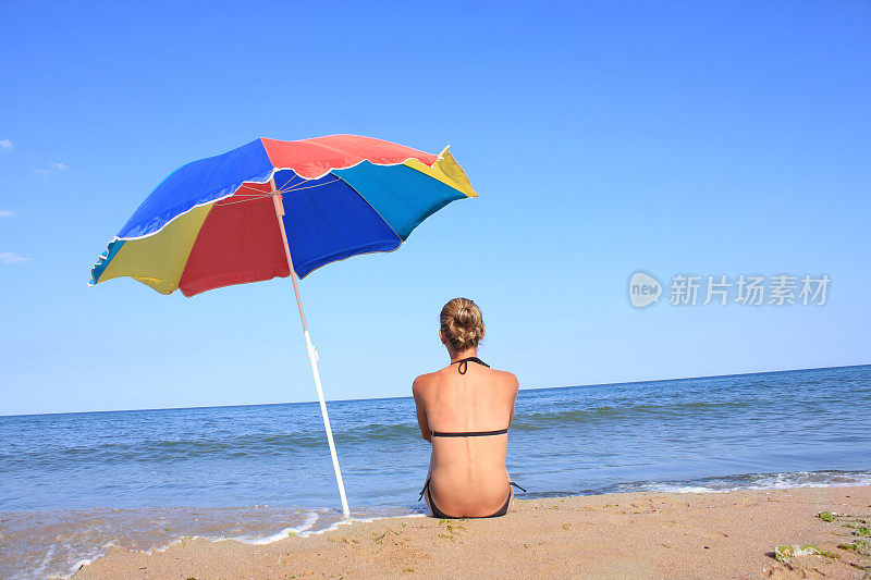 沙滩上拿着阳伞的女孩