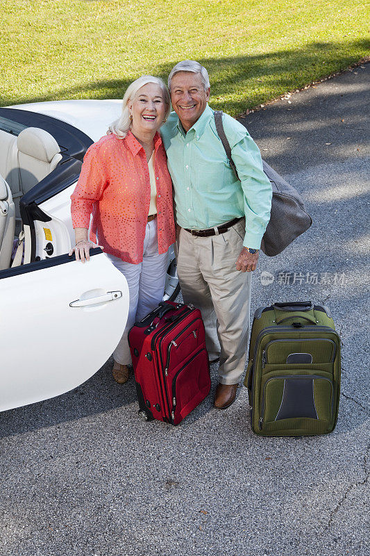 带着行李箱和敞篷车的老夫妇