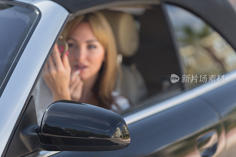 年轻女人照镜子涂口红