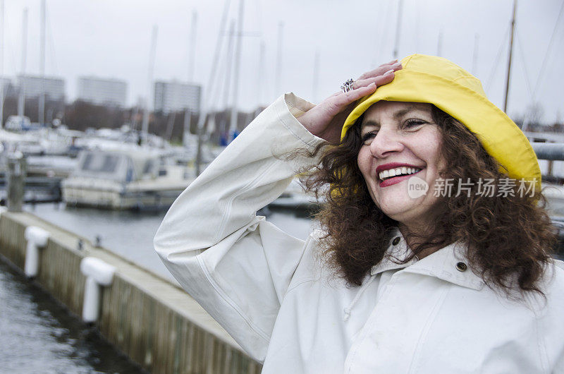 在码头享受多风天气的女人