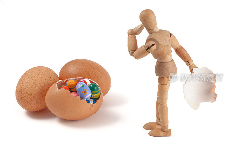 彩色的小复活节彩蛋在大鸡蛋与木制人体模型