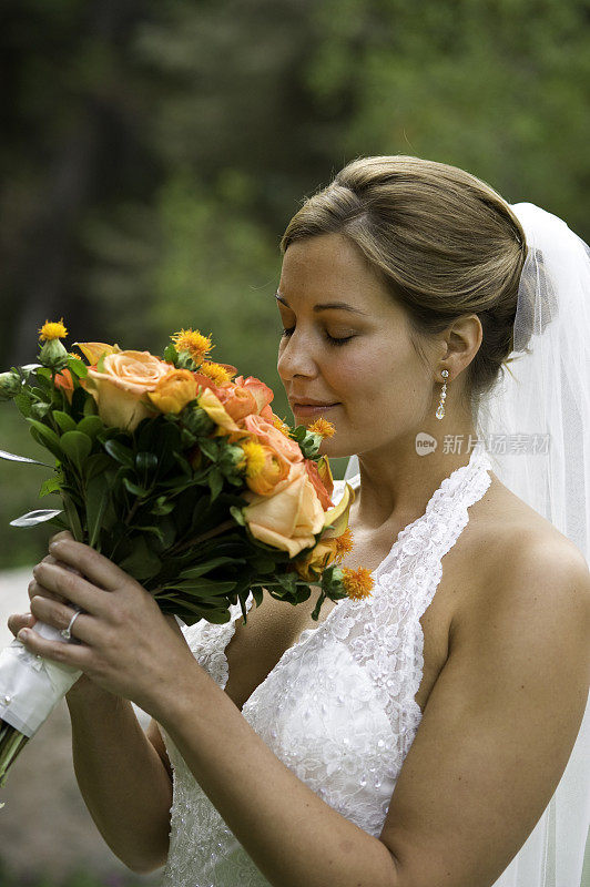 漂亮的新娘闻着婚礼上的花束