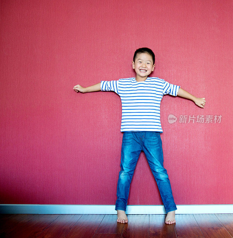 激动的小男孩靠墙站着
