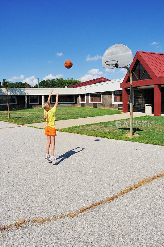 小女孩在小学操场上打篮球