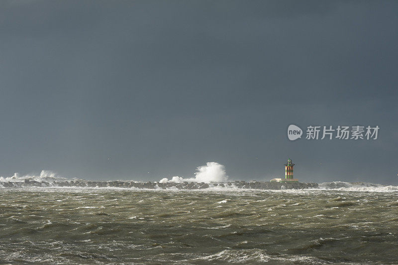 在暴风雨中非常狂暴的溅起浪花的灯塔