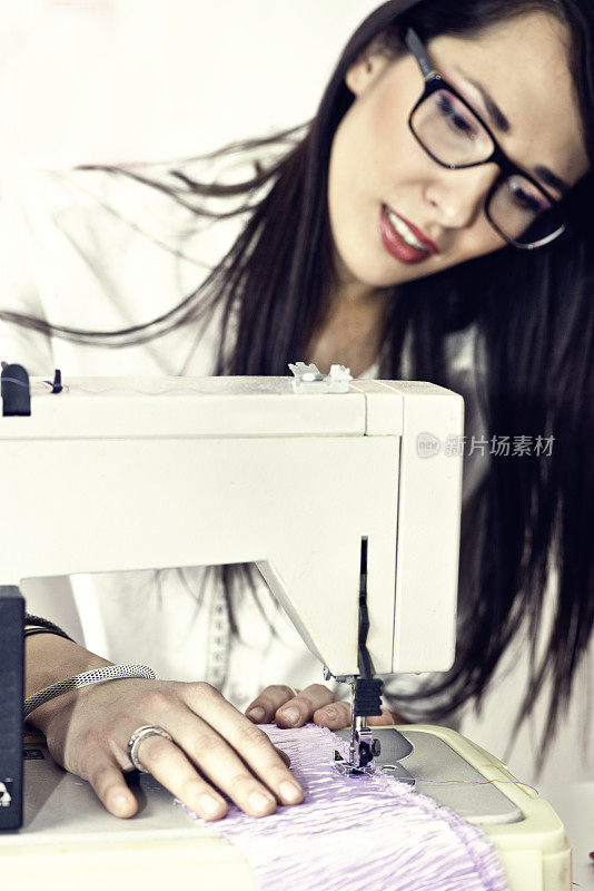 用缝纫机工作的年轻女子