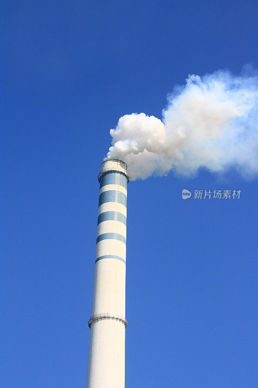 蓝天上的工业烟从烟囱里冒出来