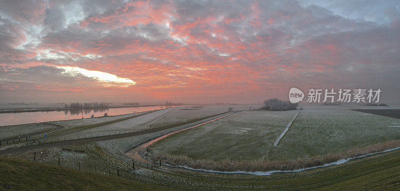 冰冻的冬季河流IJssel风景与美丽的日落