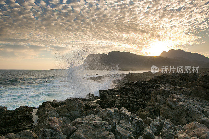 日落时海浪撞击着岩石