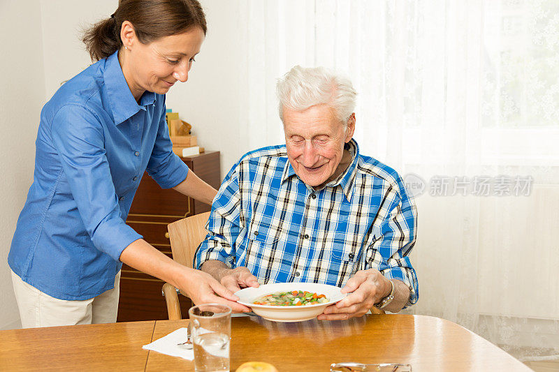护士给老人提供午餐