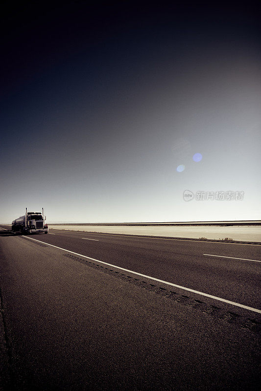 在平坦公路上孤独的半卡车和拖车