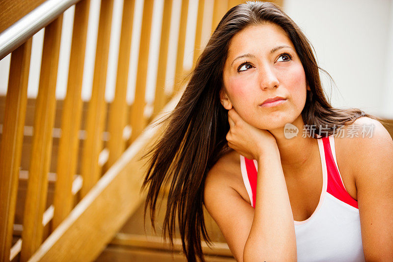 穿着运动服的漂亮年轻女人坐在楼梯上