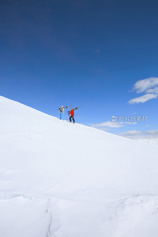 冬季运动朋友，男人和女人滑雪者携带着滑雪板