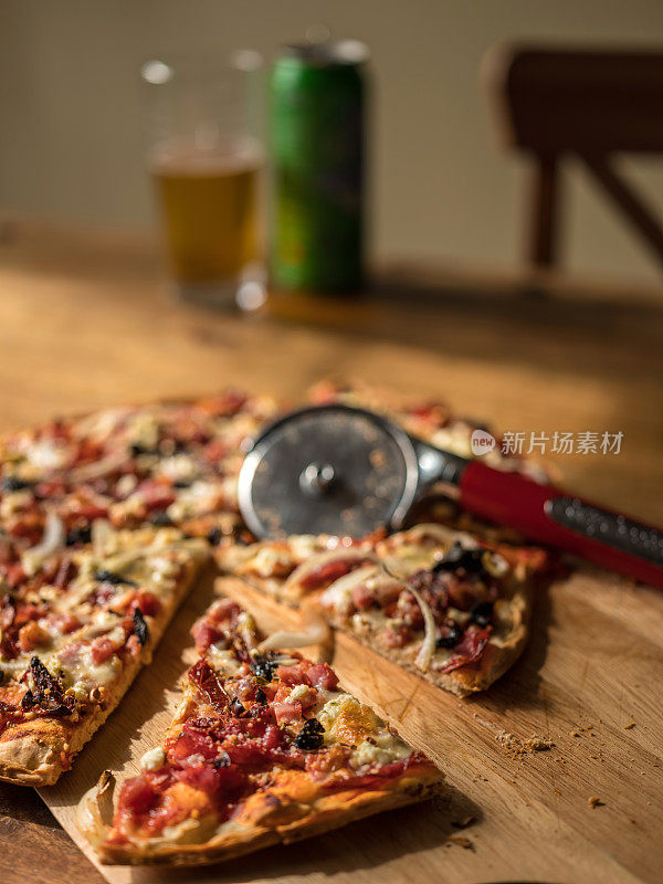 木桌上放着自制披萨和啤酒