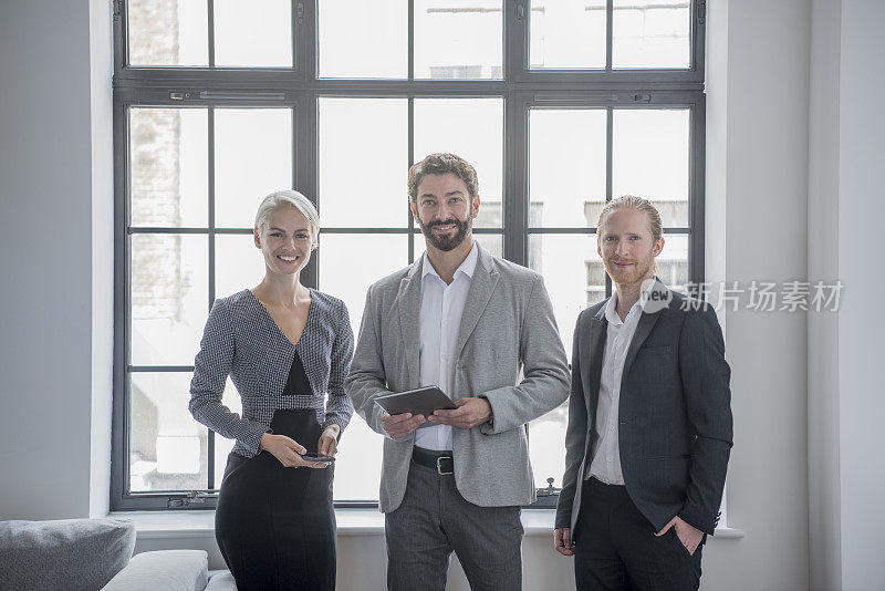三个商业同事的肖像在现代办公室，成熟的男人与平板电脑