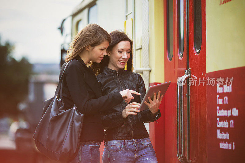 年轻女子在火车站检查平板电脑，游客