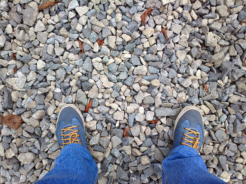 脚踩在碎石上。