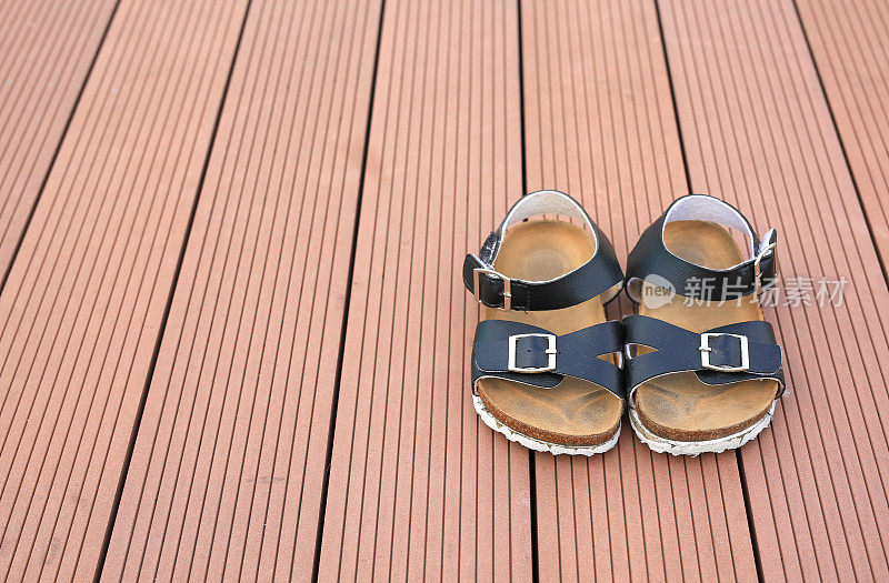 一双婴儿凉鞋上的木板背景。